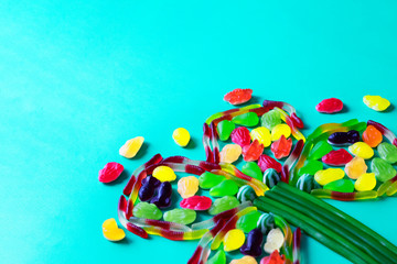 Flower made of jelly sweets in the right corner of a light green background. Make your St.Patrick's Day design sweet for real.