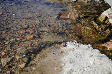 Stream in nature with the ruins of buildings and waste. Flooded building materials after the flood. Background with water for design