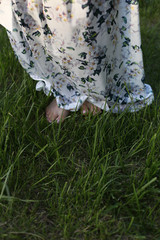 vertical photo of barefoot female feet on lush young green grass