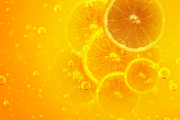 Orange juice. Halved orange in bubbling yellow liquid.
