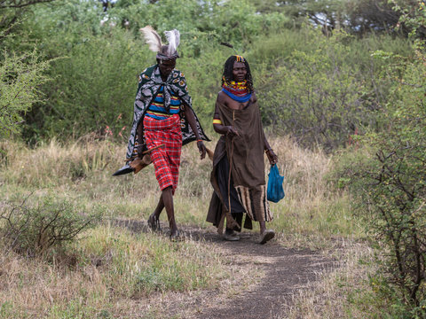 This couple represent the idigenous Turkana tribe. They were wearing very butiful traditional costumes while wakig towads their home. Lake Baringo, Kenya.