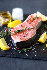 Selective focus. Salted salmon with herbs and spices on a stone board. Presentation of fish.