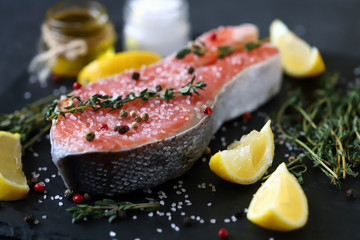Selective focus. Salted salmon with herbs and spices on a stone board. Presentation of fish.