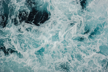 Sea ​​waves turquoise with dark blue tones and white foam, background