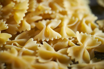 Dried farfalle short pasta background 