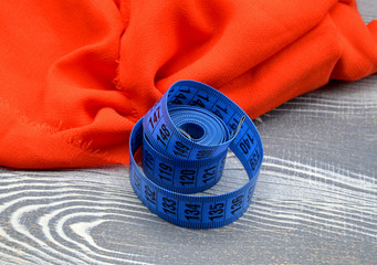 measuring tape  on red fabric background