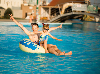 Naklejka premium Father playing with his daughter in swimming pool. Funny family weekend.