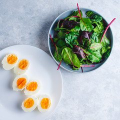 green salad with egg in a blue bowl on a blue background