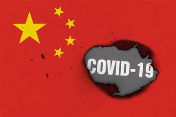 Flag of People's Republic of China with burned out hole showing Coronavirus name in it. 2019 - 2020 Novel Coronavirus (2019-nCoV) concept, for an outbreak occurs in the China.