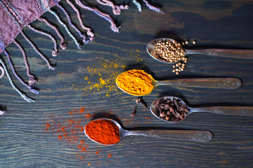 spices in spoons on a wooden table 