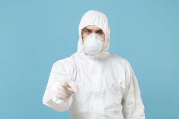 Man in white protective suit respirator mask isolated on blue background studio. Epidemic pandemic...