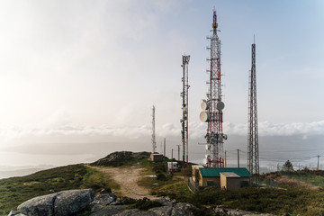 Communication Antennas on top of mountain with view of city in northern spain at sunset