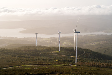 Beautiful view of field with wind turbines at sunset and cloudy sky in northern Spain