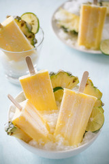 Some homemade Pineapple Popsicles (selective focus) on a rustic background