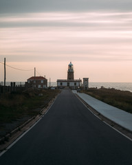 Fototapeta na wymiar Beautiful lighthouse at the end of long road at sunset in Galicia, Spain