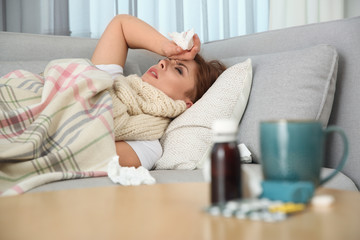 Obraz na płótnie Canvas Sick woman lying on sofa at home. Influenza virus