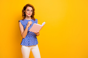 Photo of beautiful pretty lady hold planner hands look up empty space have interesting creative startup idea wear specs polka-dot blue shirt white pants isolated yellow color background