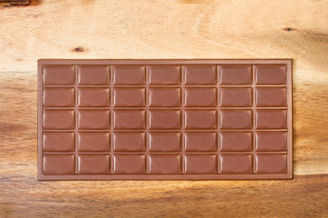 Tableta de chocolate  sobre una mesa de madera rústica. Vista superior	