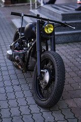 An old home-made motorcycle stands on the street. Punk and biker theme. Stock background