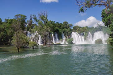 Obraz premium Beautiful view of Kravica waterfalls after heavy rains. Large tufa cascade on Trebizat River, in karstic heartland of Herzegovina. Lush surrounding and rich riparian ecosystem. Bosnia and Herzegovina