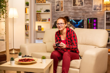 Woman gamer playing video games on the console in the living room