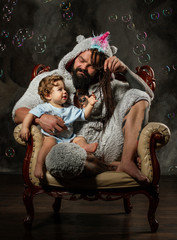 Fototapeta na wymiar dad in unicorn costume plays with happy baby