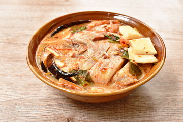 spicy boiled Tilapia fish with slice coconut shoot in tom yum milk soup on bowl