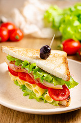 Ham sandwich on a plate on the table. Quick snack. Fast food.