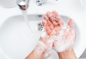 Fototapeta premium Personal hygiene, cleaning hands with soap often on faucet to protect from virus.