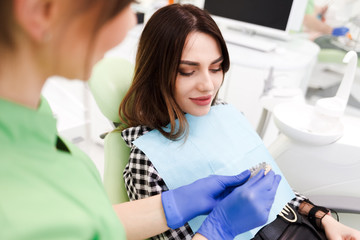 Fototapeta premium Dentist shows patient a model of teeth