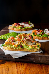 Avocado Toast. Fresh organic avocados mixed with olive oil lemon and salt and pepper paired with radishes micro greens and celery leaves. Spread on whole grain crispy toast. New American favorite.