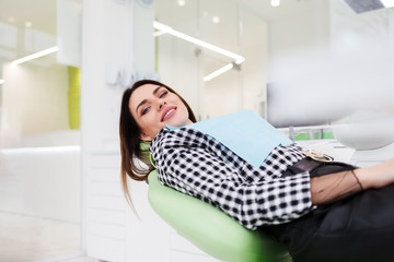 Smiling woman lies in the chair of the dental office