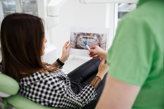 Dentist doctor shows an x-ray of the oral cavity to his patient