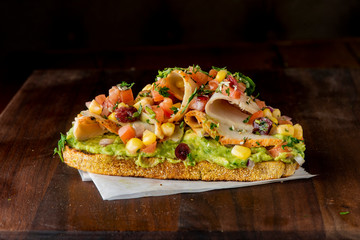 Avocado Toast. Fresh organic avocados mixed with olive oil lemon and salt and pepper paired with radishes micro greens and celery leaves. Spread on whole grain crispy toast. New American favorite.