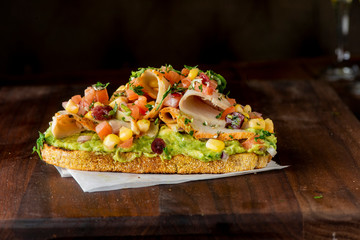Avocado Toast. Fresh organic avocados mixed with olive oil lemon and salt and pepper paired with radishes micro greens and celery leaves. Spread on whole grain crispy toast. New American favorite.