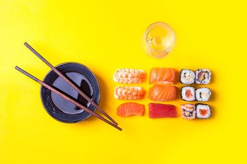 Varias porciones de Sushi ordenadas con salsa de soja y vino blanco