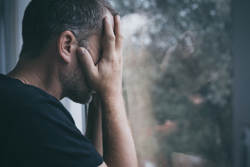 portrait one sad man standing near a window