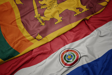 waving colorful flag of paraguay and national flag of sri lanka.