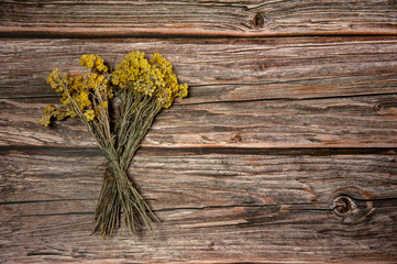 Phytotherapy. Composition of dry herbs for herbal medicine. A bunch of dried tansy grass (Tanacetum vulgare) on a wooden background. Free space.