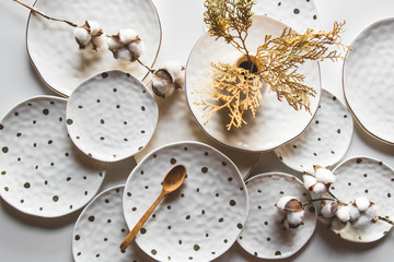 Beautiful plates on a white background with cotton. Beautiful layout