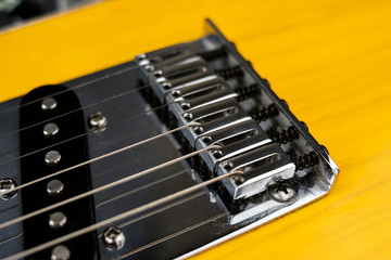 Chrome strings tensioners on a lacquered wooden electric guitar