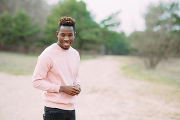 Happy African man stands and smiles.