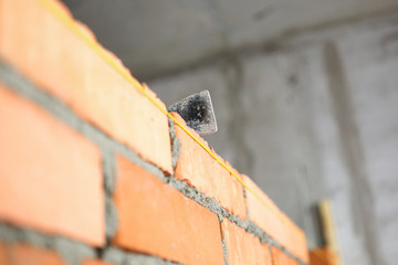 Mallet lying on top of brick wall as building and renovation