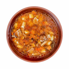Wild forest mushroom mushroom soup in brown clay plate isolated on white background