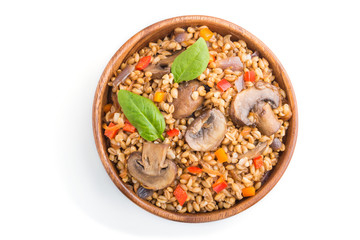 Spelt (dinkel wheat) porridge with vegetables and mushrooms in wooden bowl isolated on white background. Top view, close up.