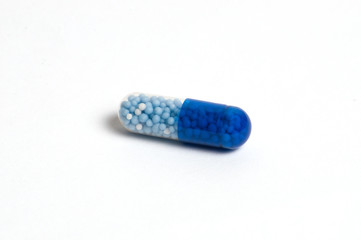 One tablet, vitamin capsule on white background, isolate. The concept of medicine and protection...