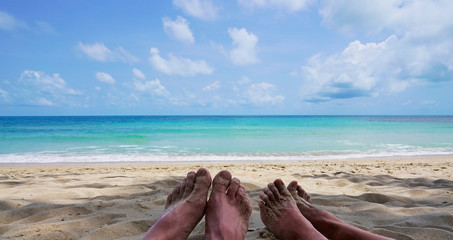 Fototapeta na wymiar Two feets women and men on the beach with beautiful blue azul sea.