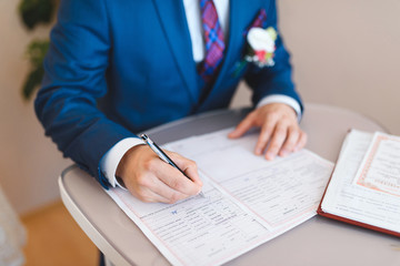 groom signing wedding certificate