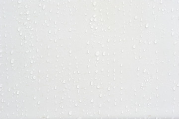 Beautiful water drops at a clean wall in difference sizes from small ones to big ones nice and...