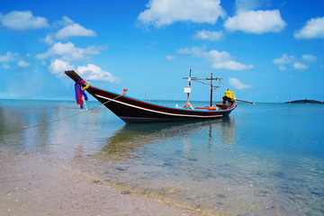 The thai boat in the blue sea.